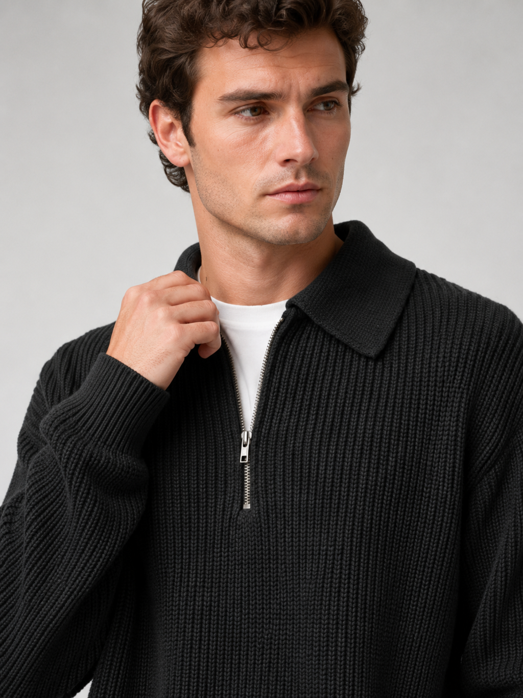 Close up of black quarter zip polo sweater showing soft knit texture and turn down collar zipper detail