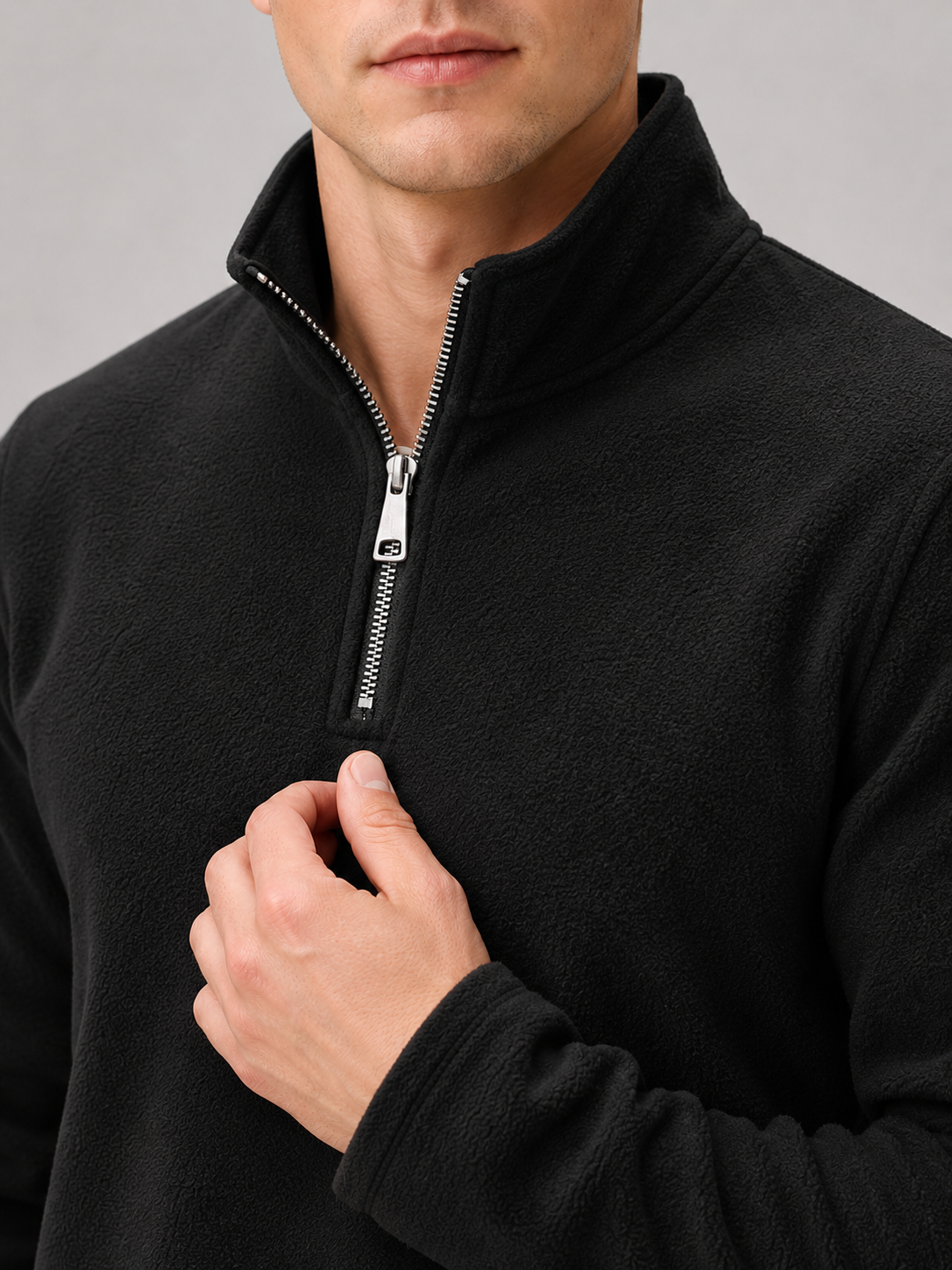 Close up of black fleece pullover showing soft thermal fabric and quarter zip mock neck detail