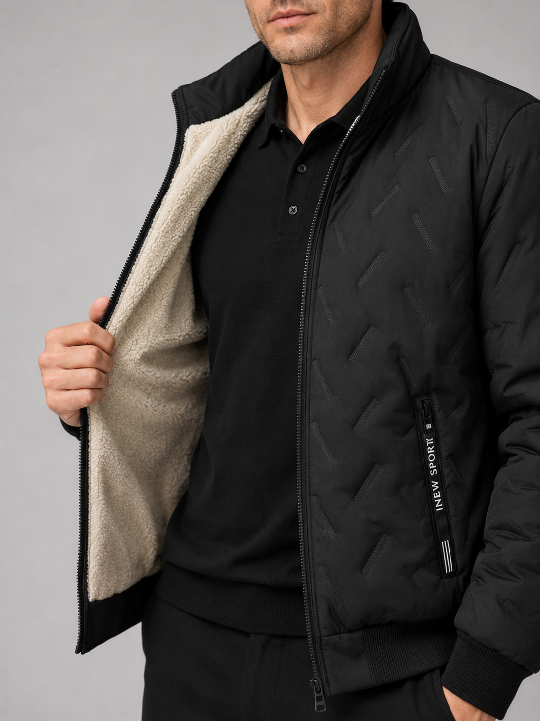 Close up of black quilted jacket showing insulated quilted stitching, stand collar, and zip front detail