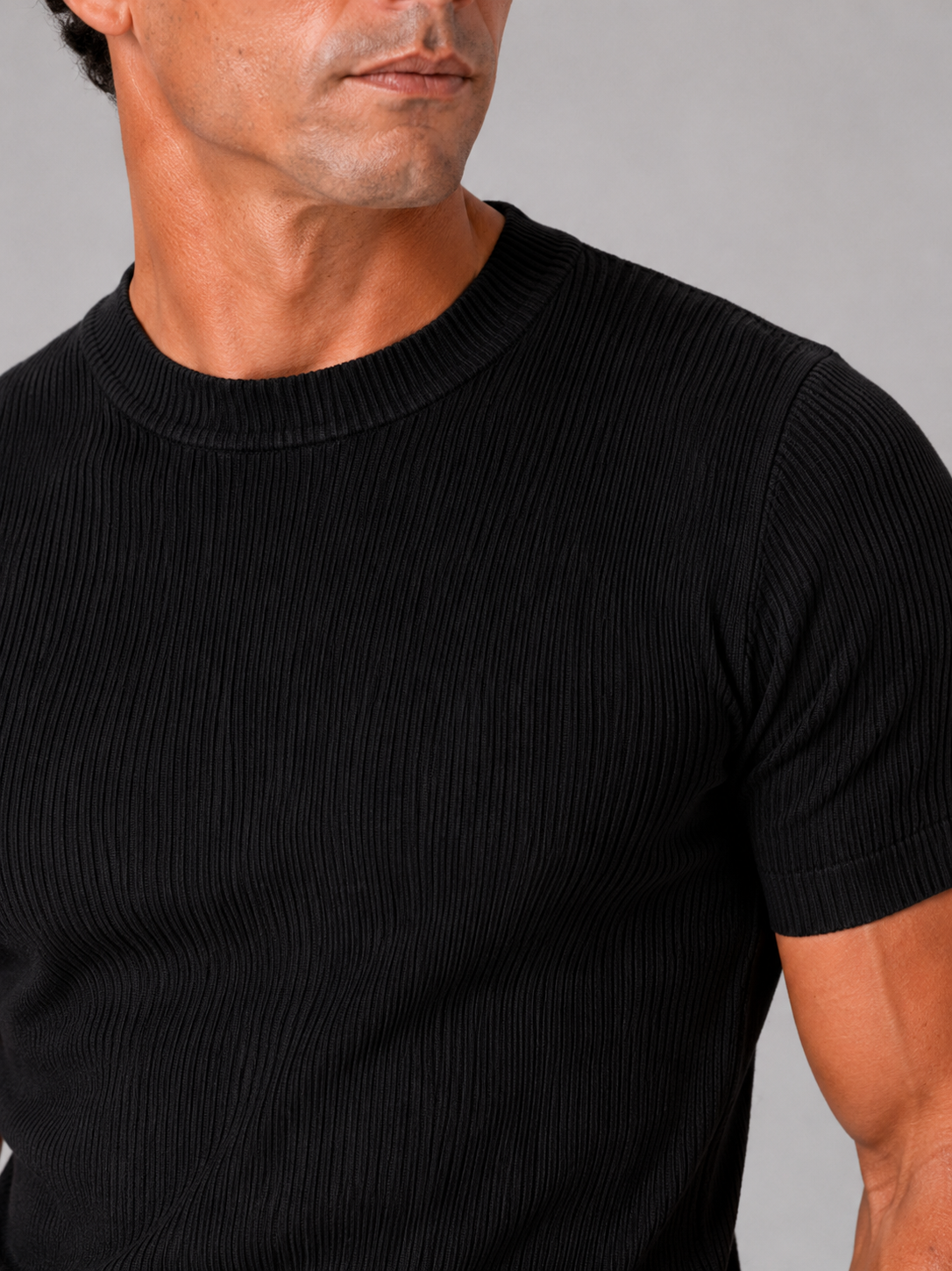 Close up of black ribbed t shirt showing soft stretch fabric and textured crew neck detail