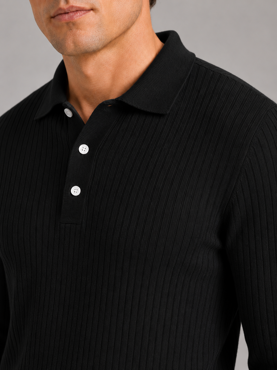 Close up of black ribbed polo shirt showing soft textured fabric and refined collar detail