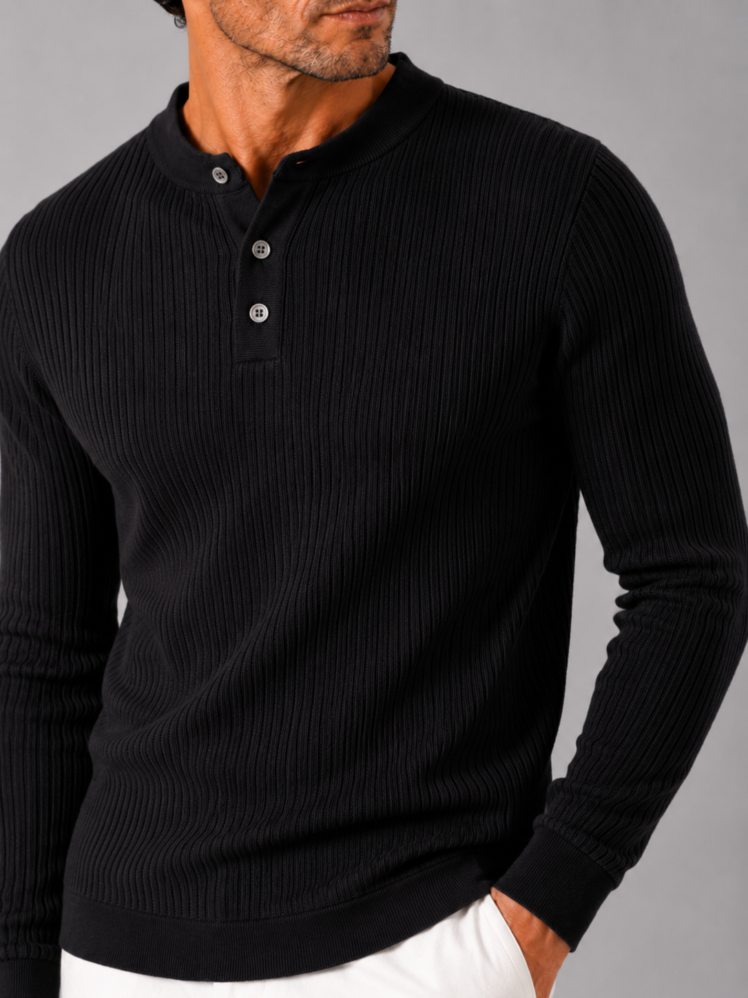 Close up of black ribbed henley polo showing striped knit texture and button detail