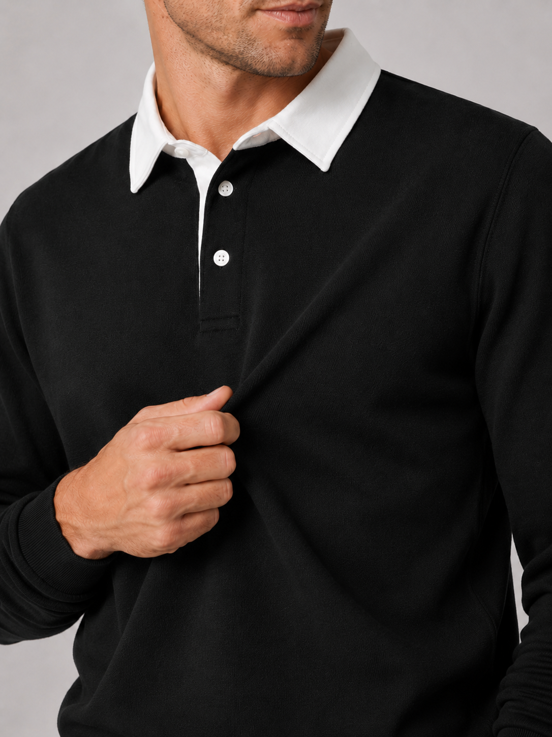 Close up of black rugby polo shirt showing soft knit fabric and classic collar detail