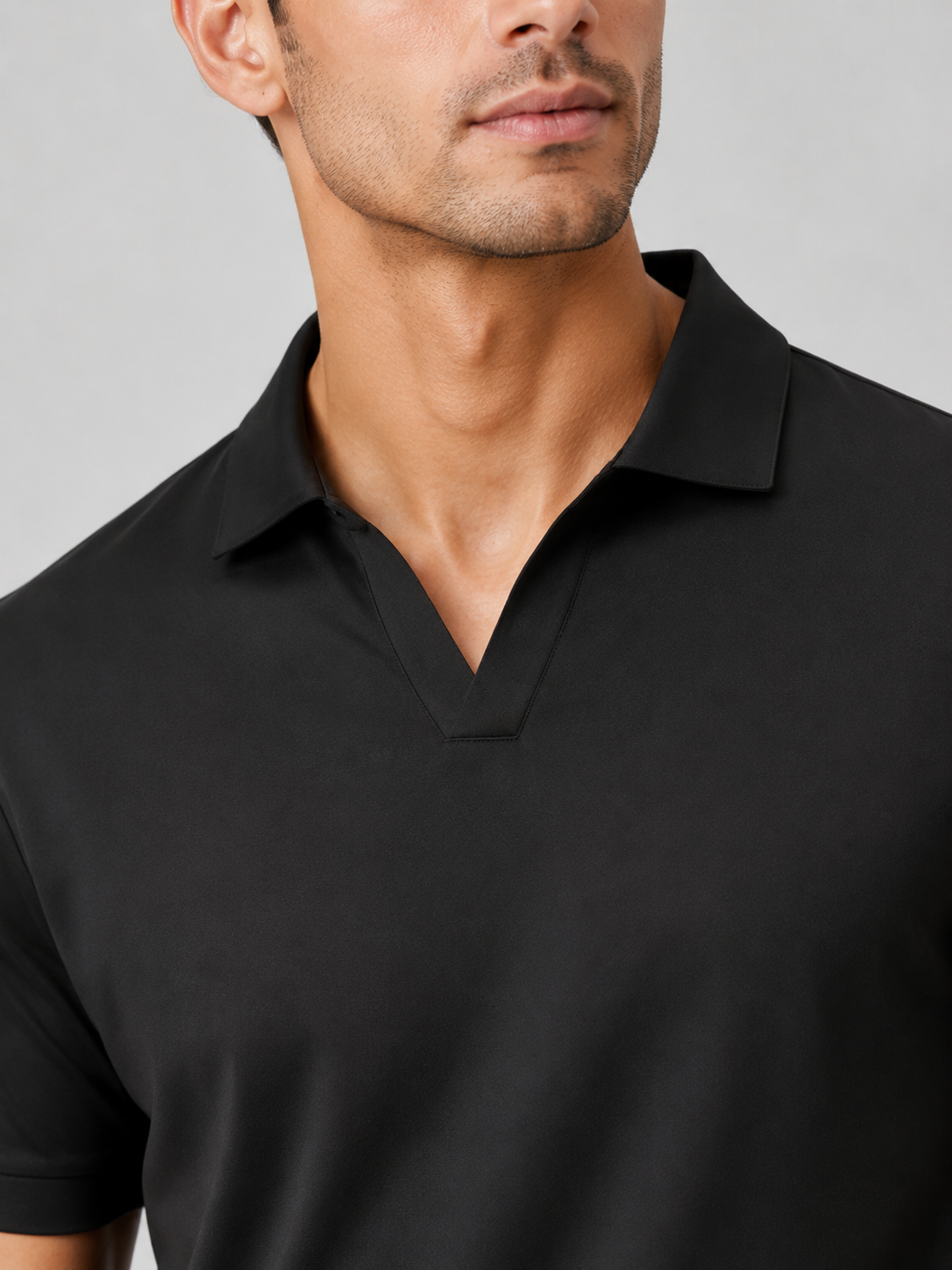 Close up of black polo shirt showing smooth silky fabric and refined collar detail