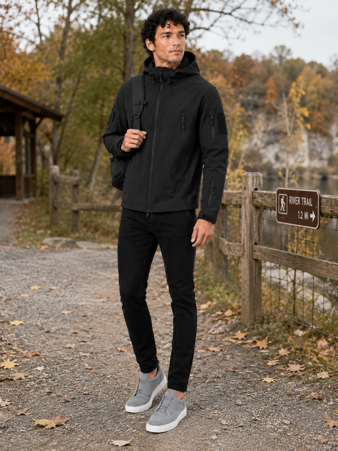 Man styling black tactical hooded jacket in a rugged outdoor work and hiking lifestyle outfit