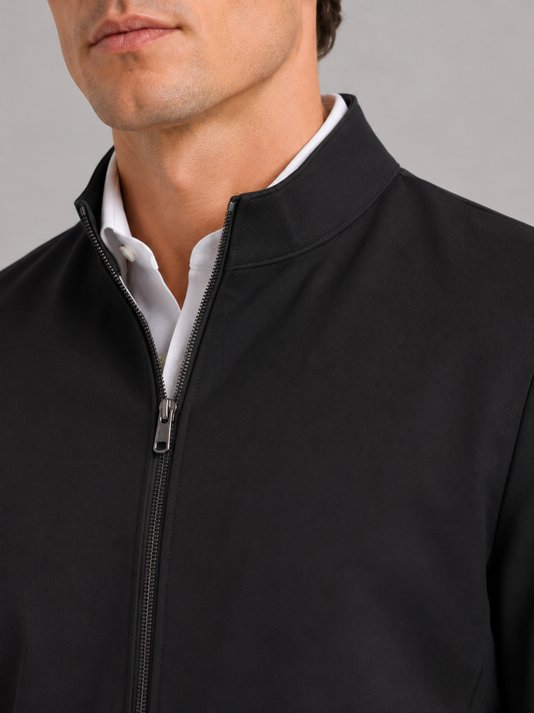 Close up of black workwear jacket showing durable wear resistant fabric and stand collar detail
