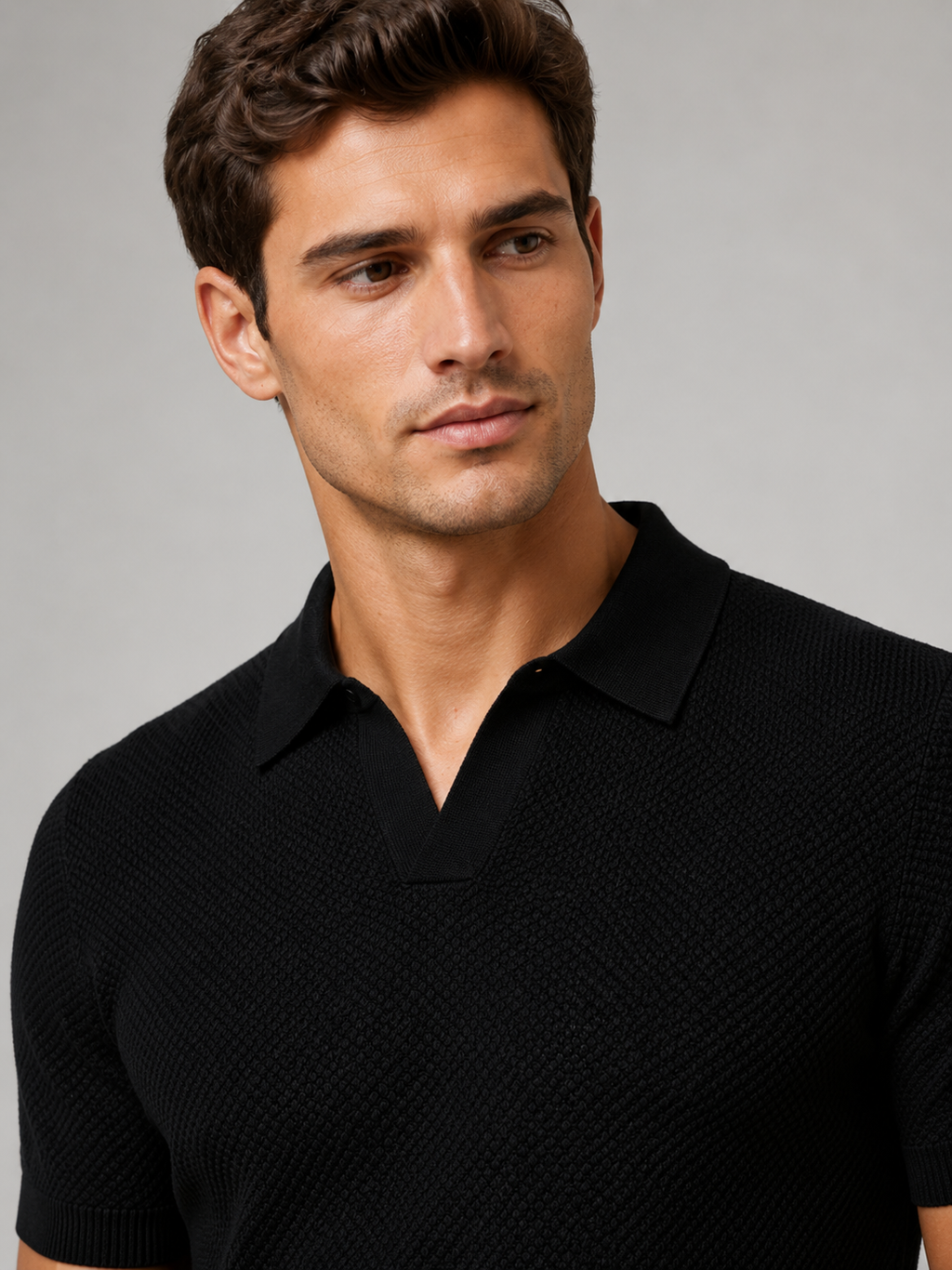 Close up of black knit polo showing soft breathable stretch fabric and refined collar detail