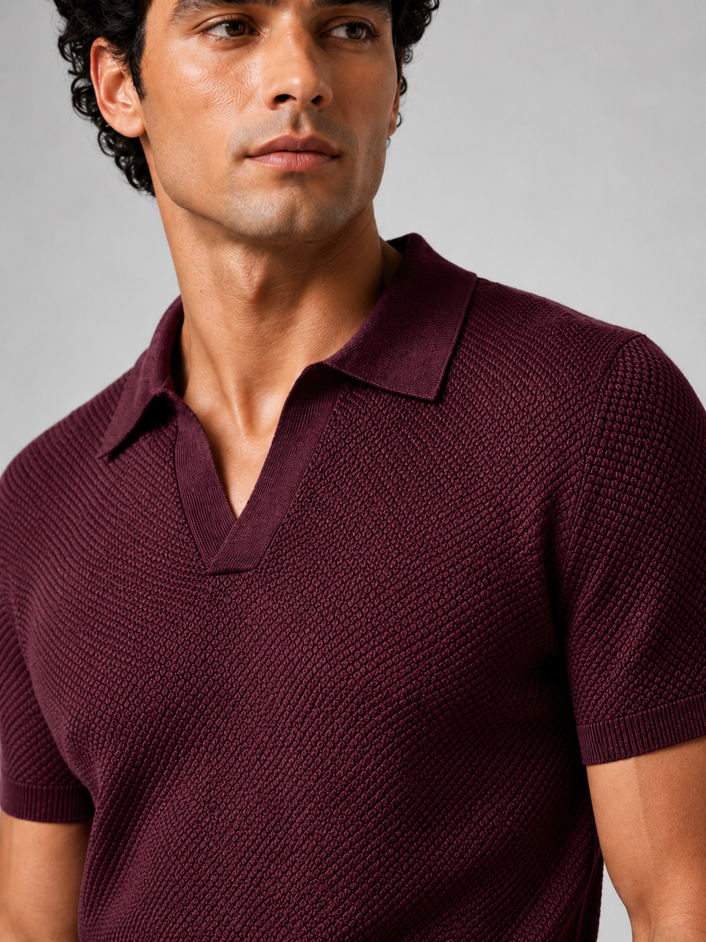 Close up of wine knit polo showing soft breathable stretch fabric and refined collar detail