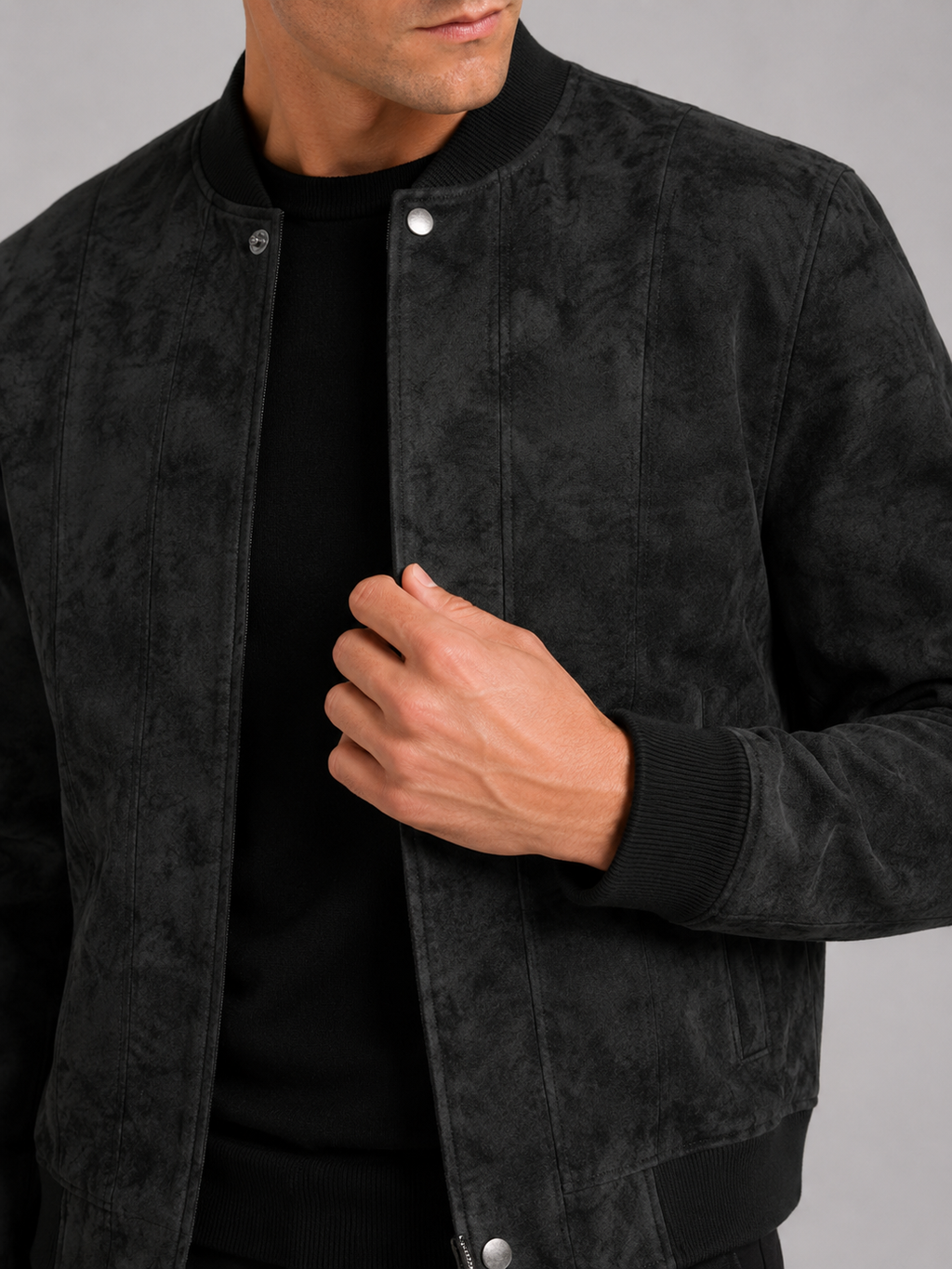 Close up of black suede bomber jacket showing soft suede texture and stand collar zipper detail