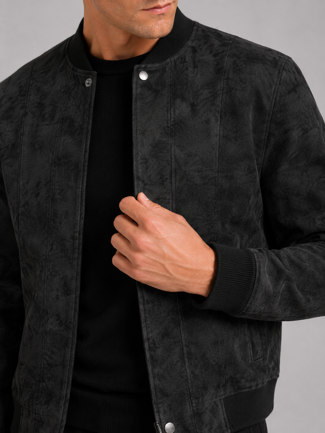 Close up of black suede bomber jacket showing soft suede texture and stand collar zipper detail