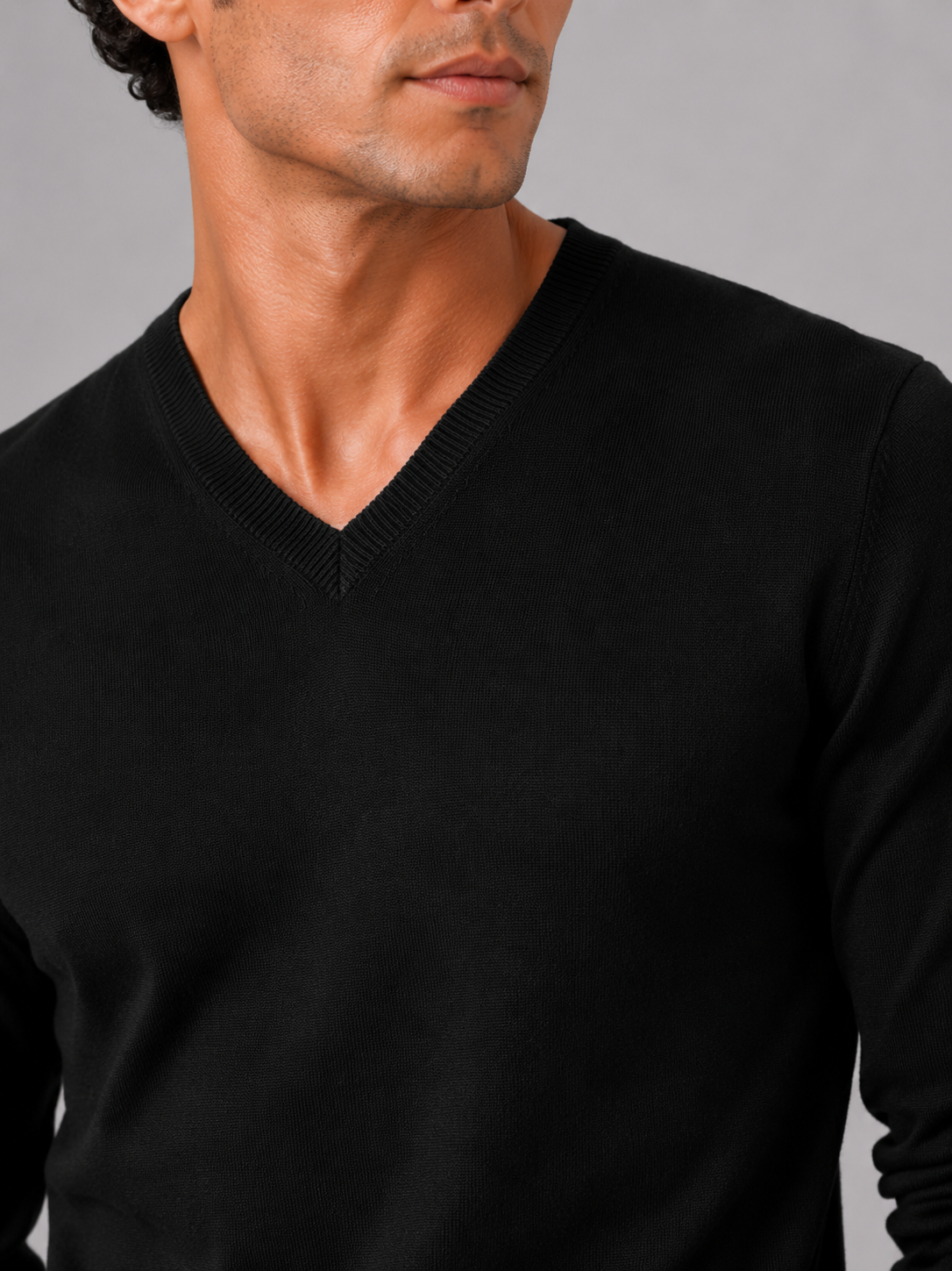 Close up of black knit sweater showing soft lightweight fabric and refined v neck detail