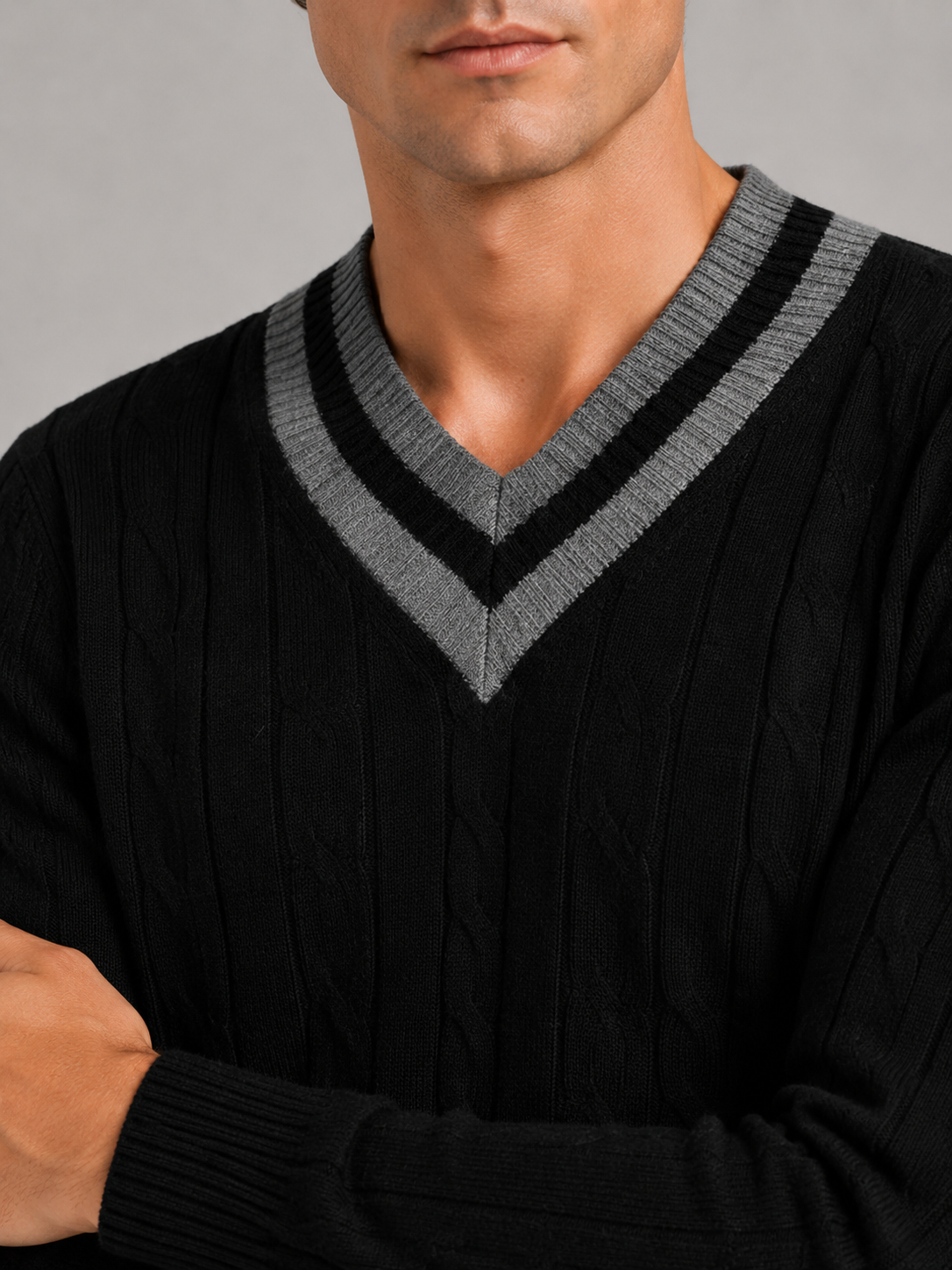 Close up of black knit sweater showing soft warm fabric and refined v neck detail