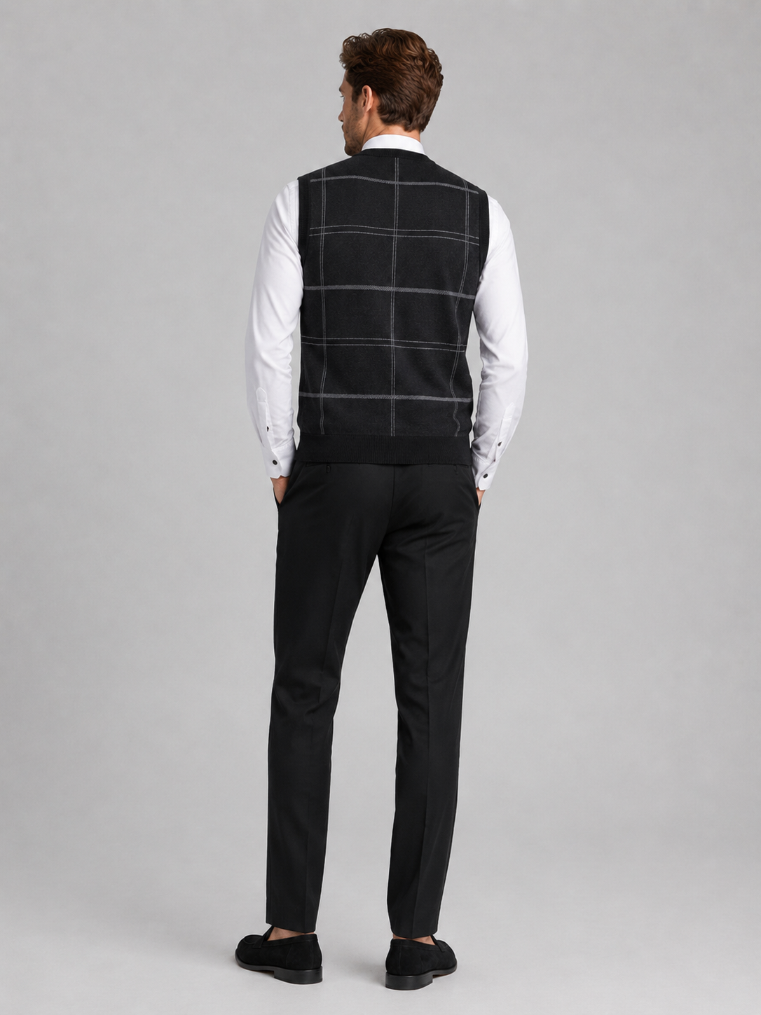 Back view of a man wearing a black V-neck sweater vest showing the sleeveless cut, warm knit fabric, and comfortable fit