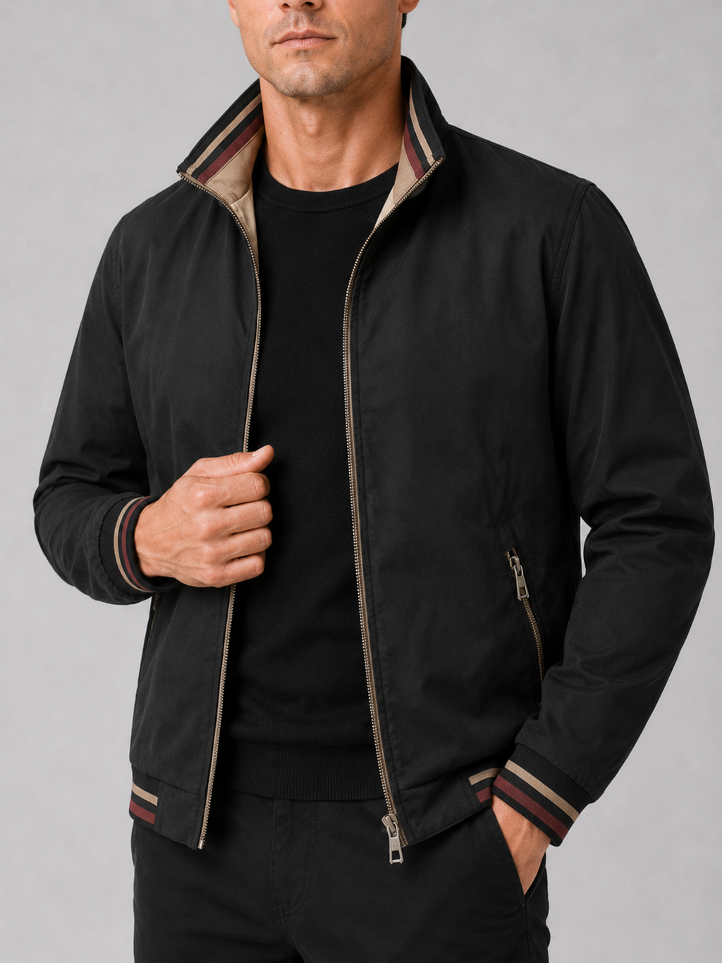 Close up of black varsity jacket showing snap button closure and reversible design detail