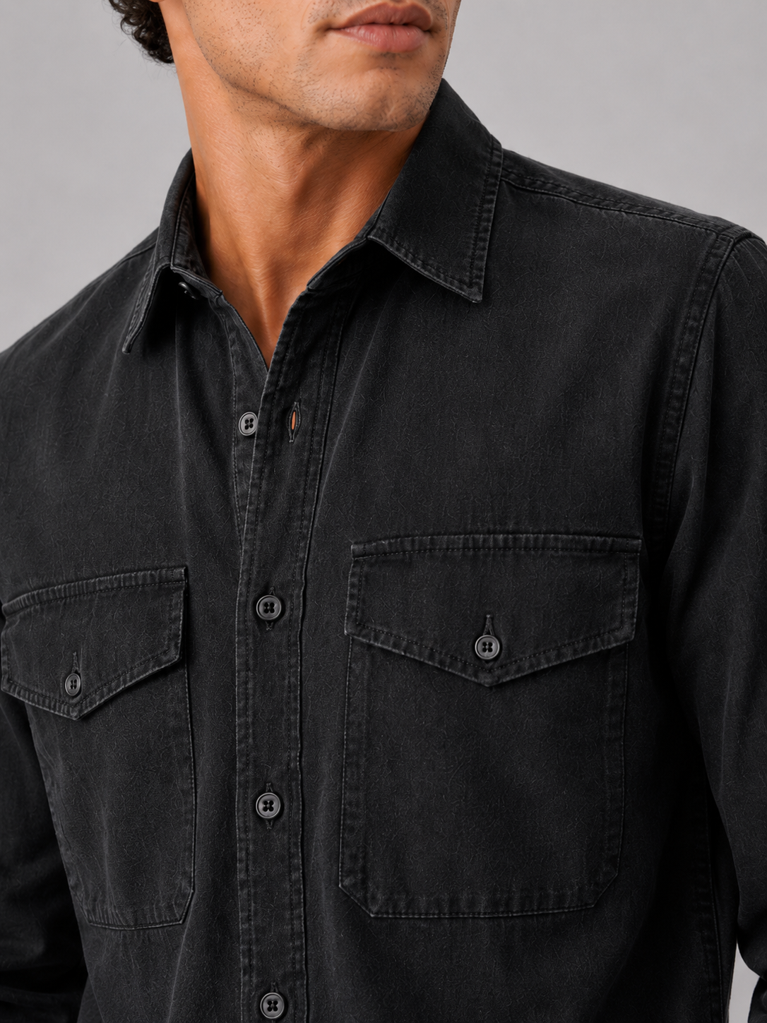 Close up of black washed cotton work shirt showing soft fabric texture and pocket detail
