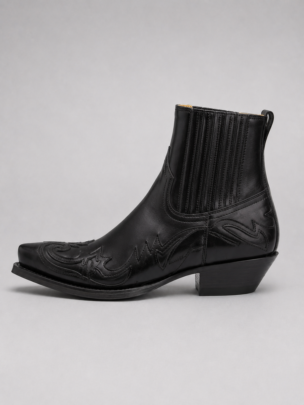 Side view of black men’s western cowboy boots showing embroidered leather upper, pointed toe, stacked heel, and ankle boot silhouette