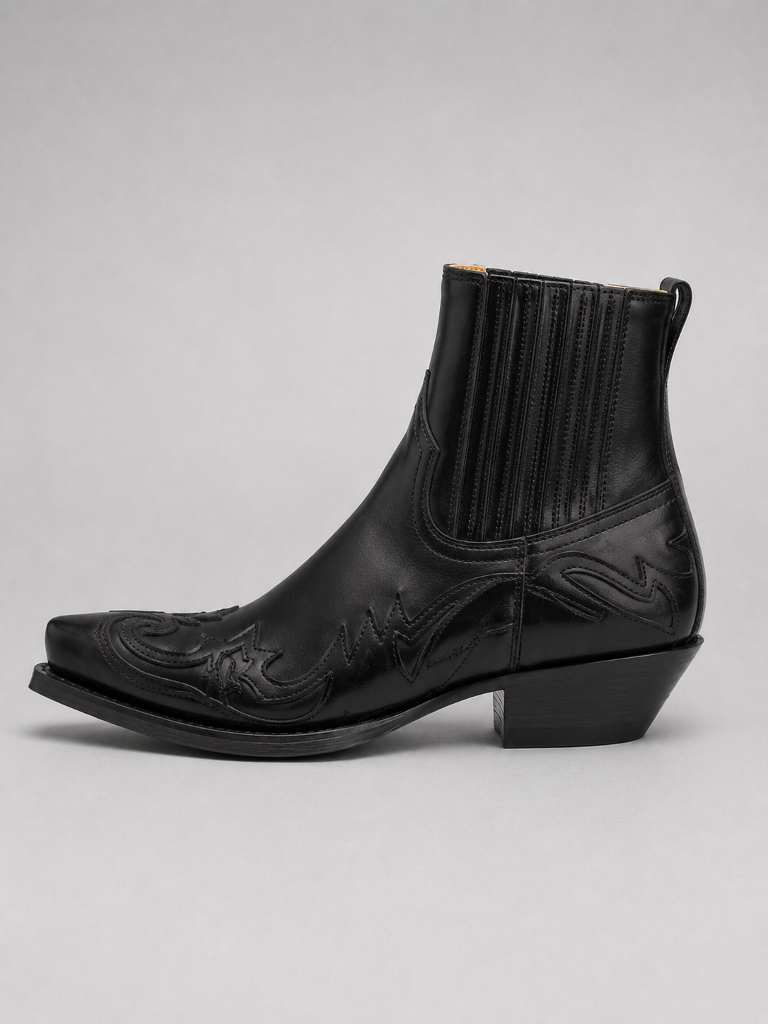 Side view of black men’s western cowboy boots showing embroidered leather upper, pointed toe, stacked heel, and ankle boot silhouette