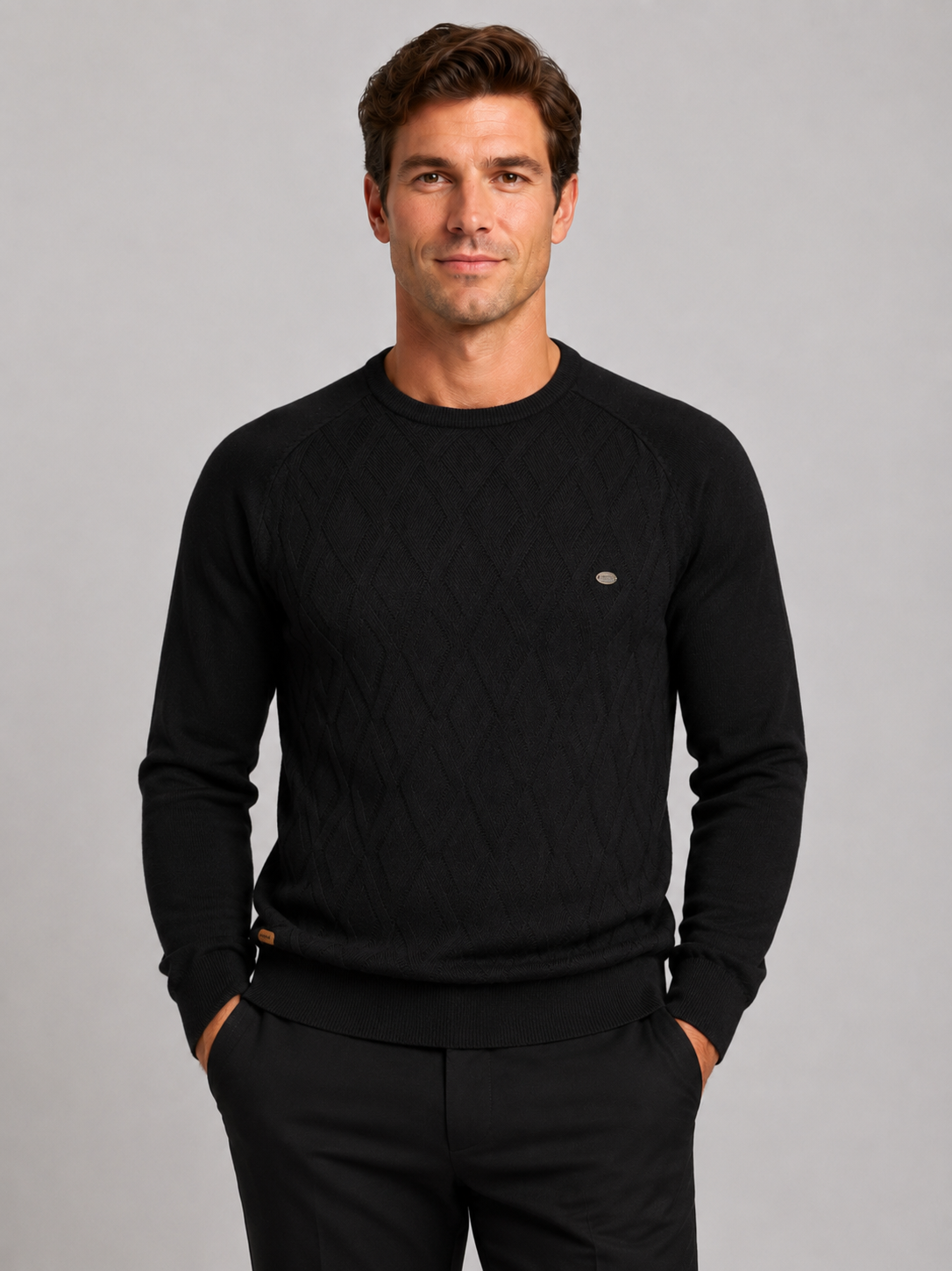 Front view of a man wearing a black argyle crew neck sweater with long sleeves and a warm knit pattern