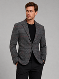 Front view of a man wearing a black checkered blazer with a slim fit, notched lapel, and tailored business casual design