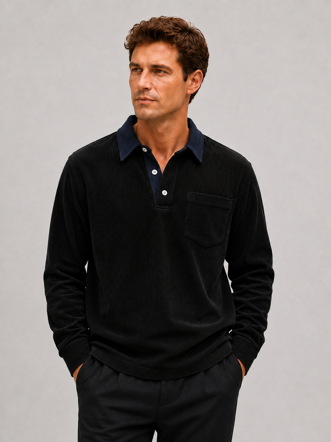 Front view of a man wearing a black corduroy long sleeve polo shirt with a contrast turn-down collar and relaxed fit