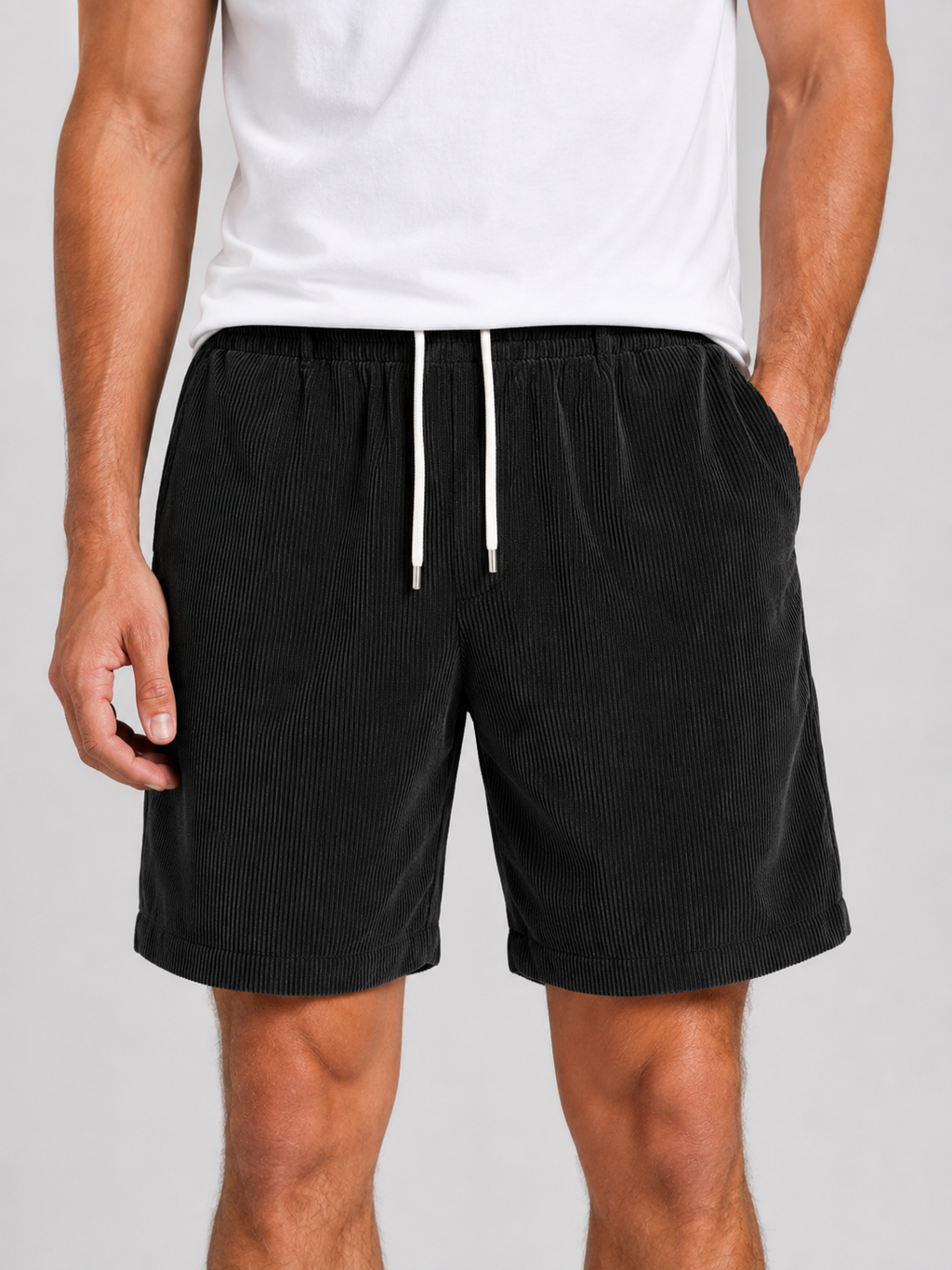 Close up of black corduroy shorts showing soft textured fabric and adjustable drawstring waistband
