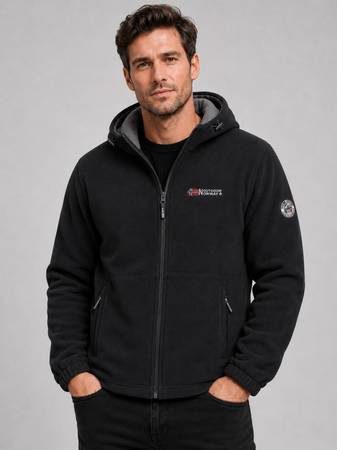 Front view of a man wearing a black hooded fleece jacket with a windproof design, thick warm construction, and full zip front