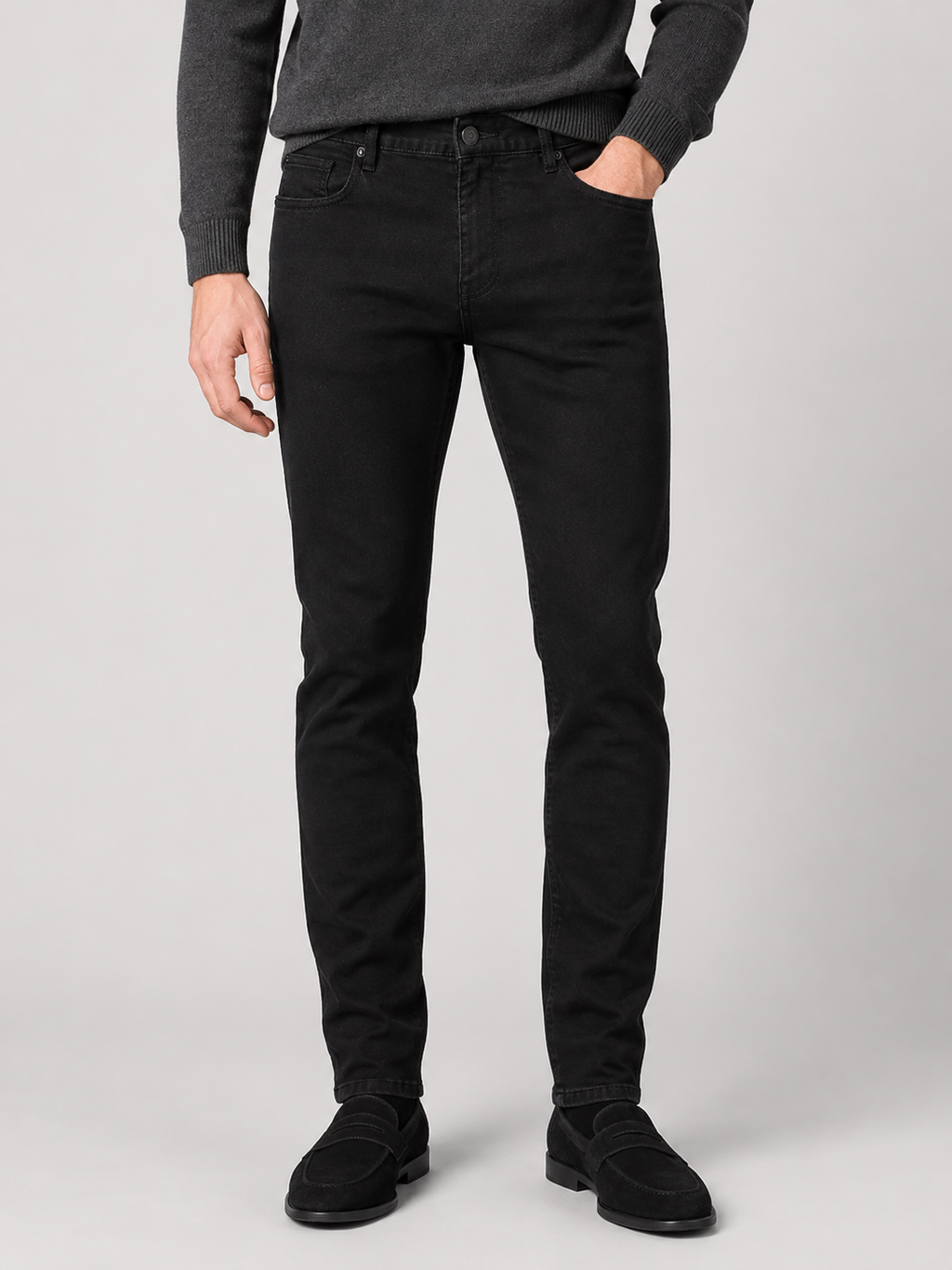 Front view of a man wearing black stretch denim jeans with a slim fit, classic five-pocket design, and modern casual style