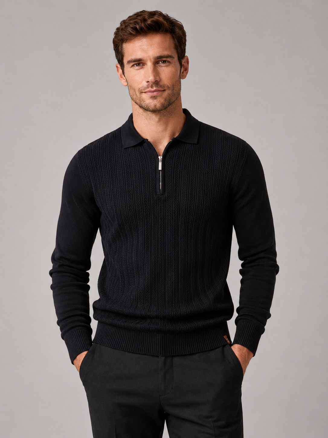 Front view of a man wearing a black quarter zip polo shirt with a slim fit, textured fabric, long sleeves, and structured collar