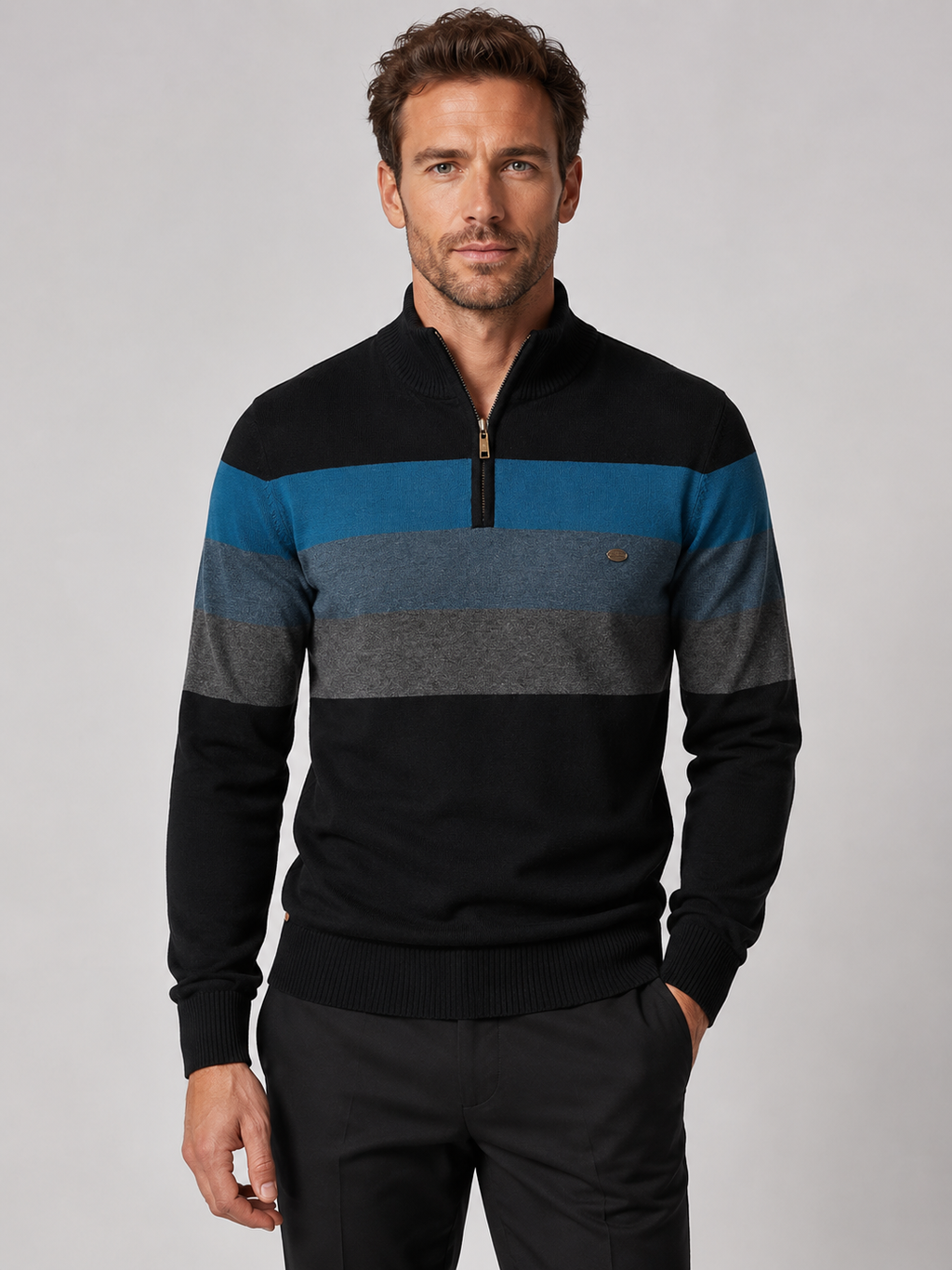 Front view of a man wearing a black patchwork cotton quarter zip sweater with a mock neck and long sleeves