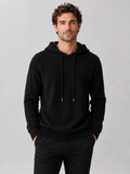 Front view of a man wearing a black wool hoodie sweater with a soft knit design, attached hood, and long sleeves
