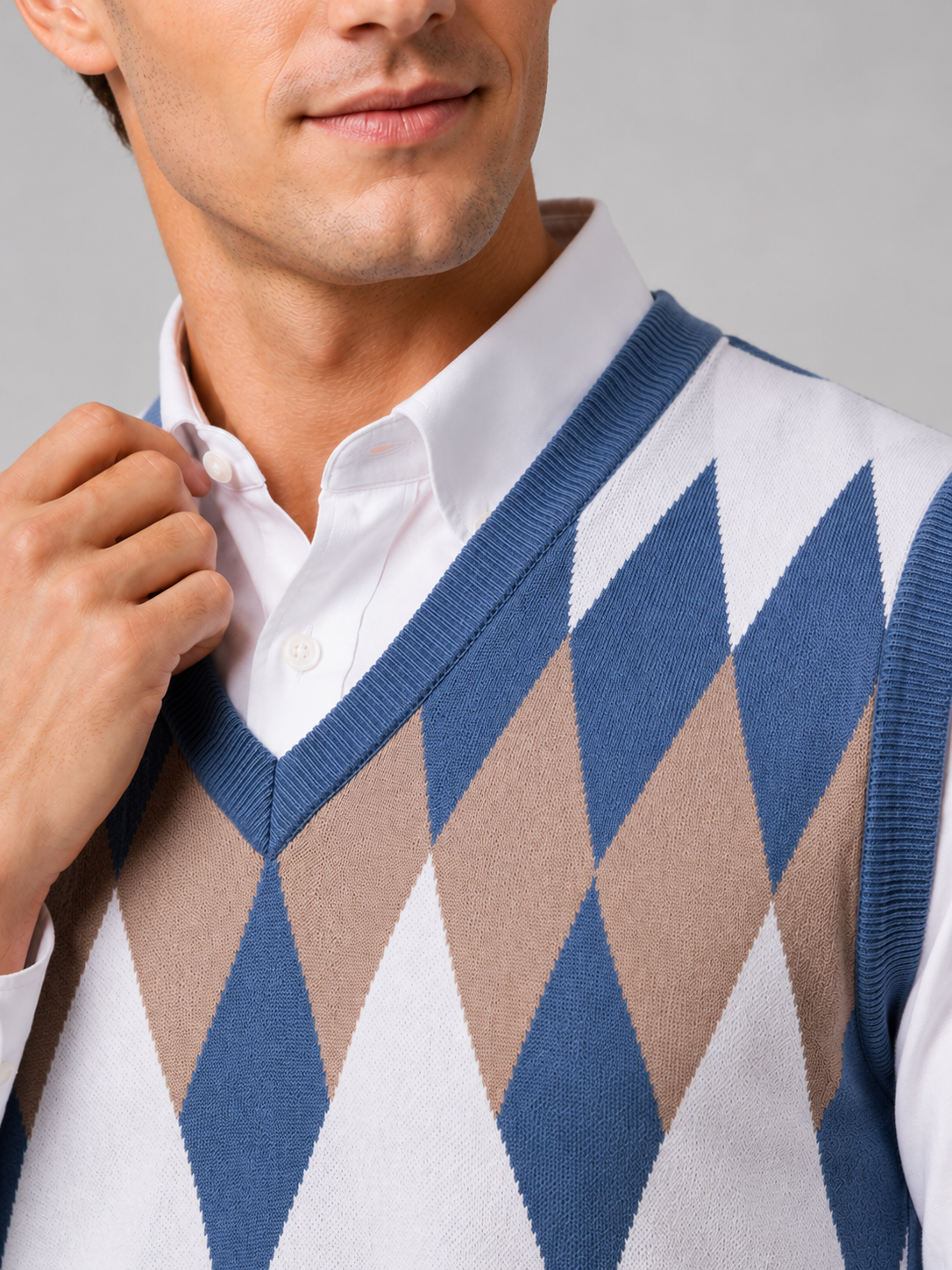 Close up of blue argyle sweater vest showing classic diamond knit pattern and refined v neck detail