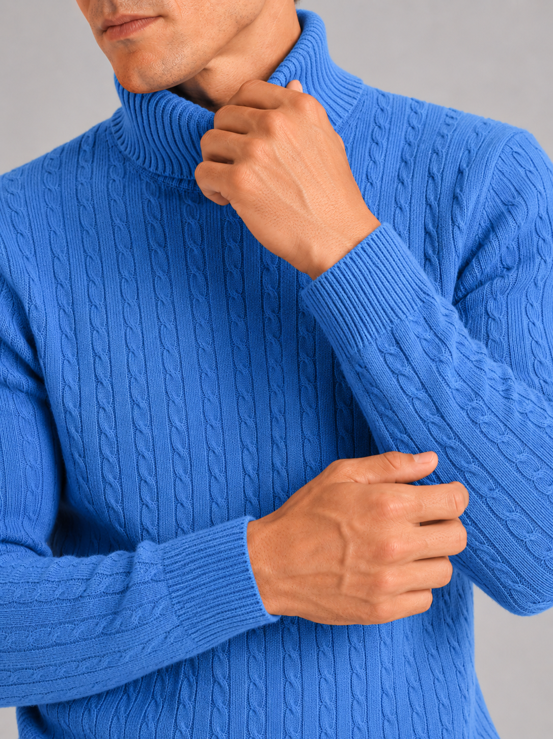 Close up of blue cable knit turtleneck showing thick textured fabric and warm collar detail