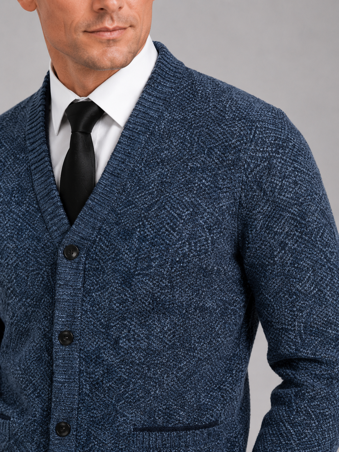 Close up of blue knit cardigan showing soft textured fabric and refined button front detail