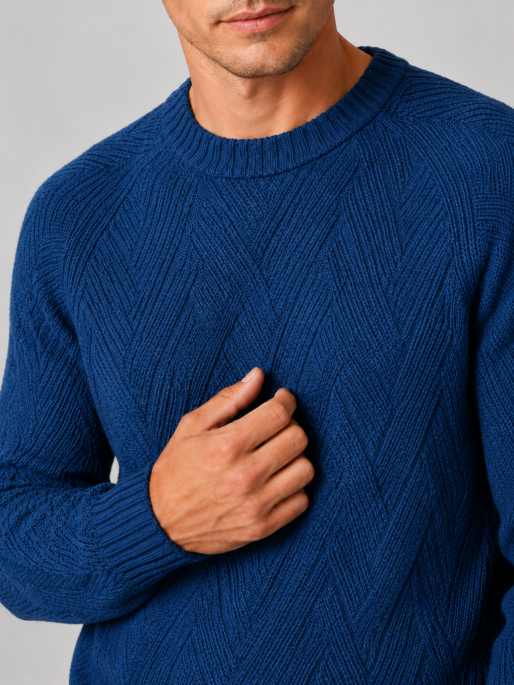 Close up of blue knit sweater showing soft textured fabric and classic crew neck detail