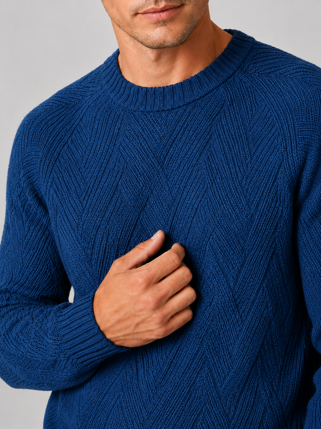 Close up of blue knit sweater showing soft textured fabric and classic crew neck detail
