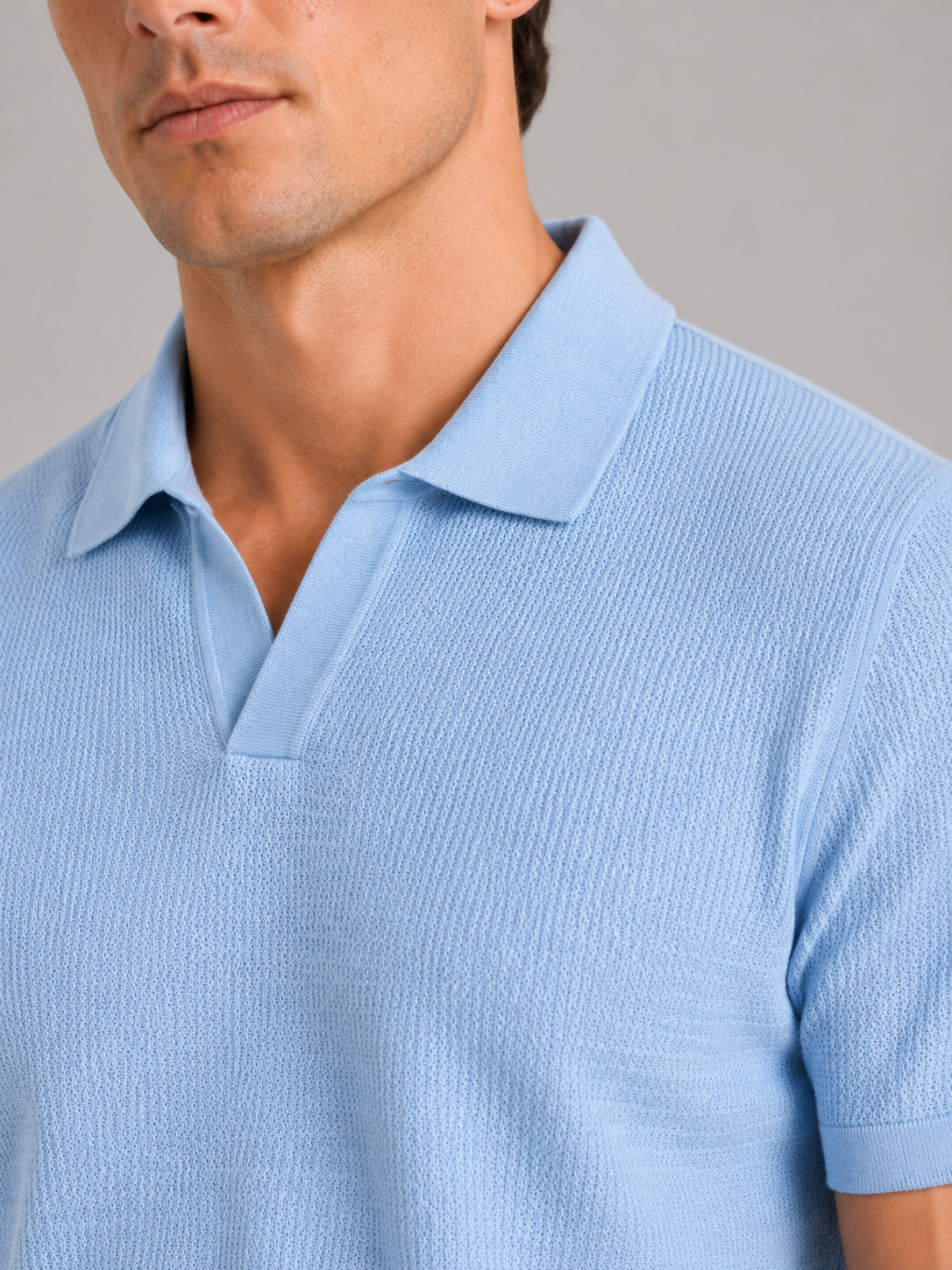 Close up of blue knit polo t shirt showing soft breathable fabric and refined collar detail