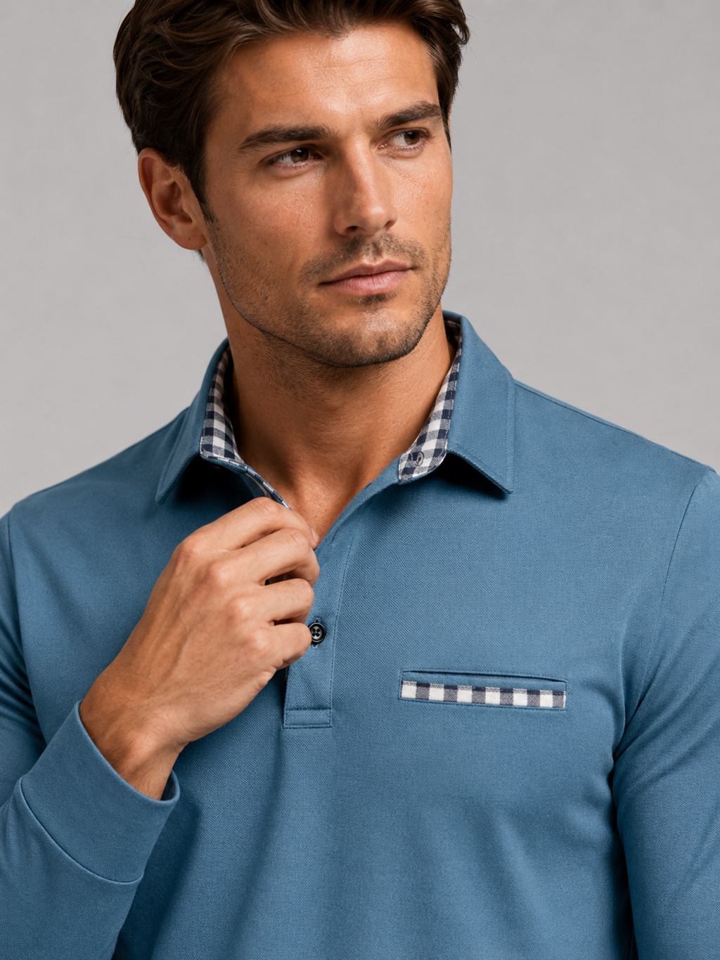 Close up of blue polo shirt showing plaid panel detail, soft fabric, and classic collar