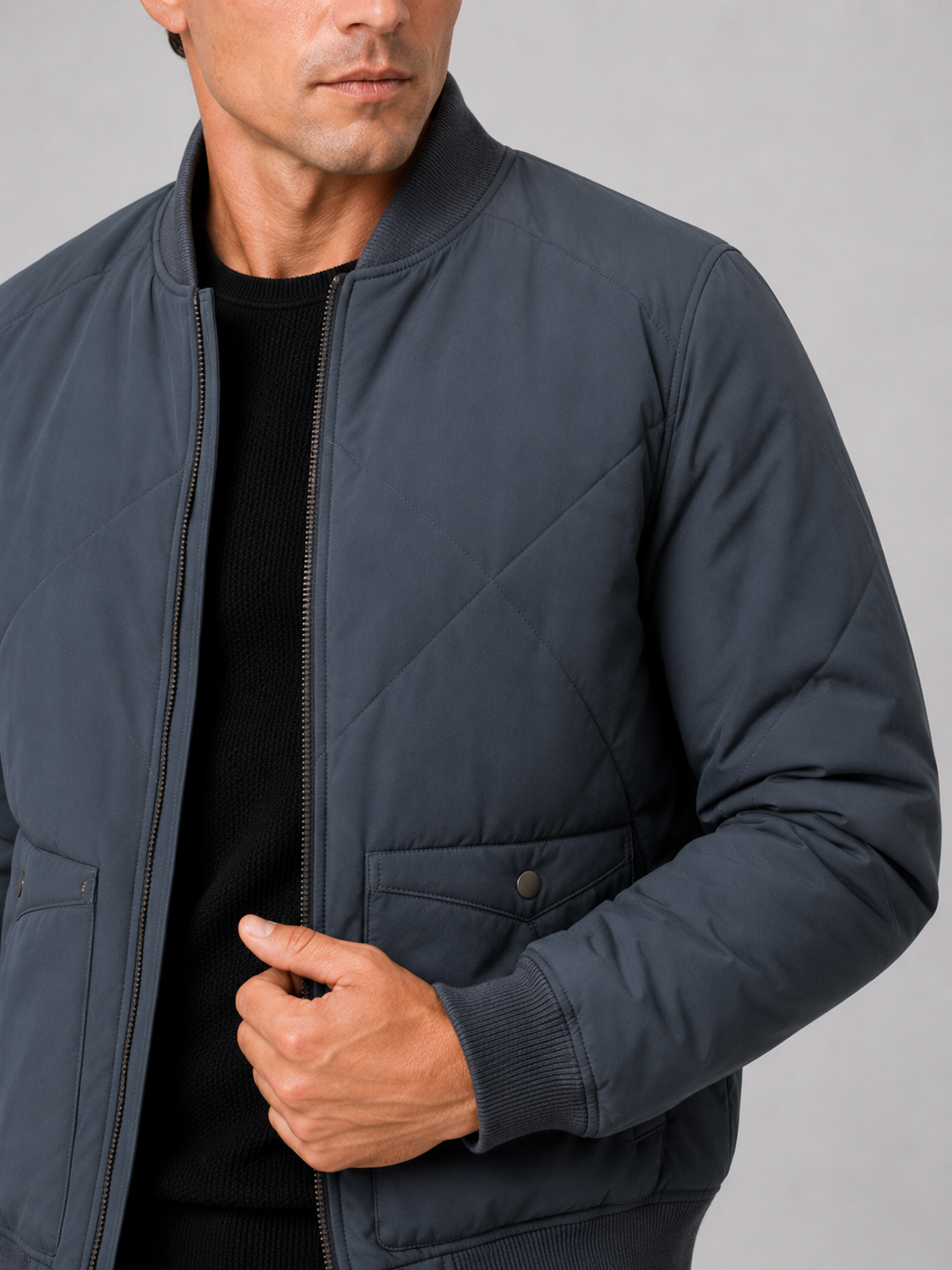 Close up of blue padded baseball jacket showing insulated cotton fabric and snap front detail