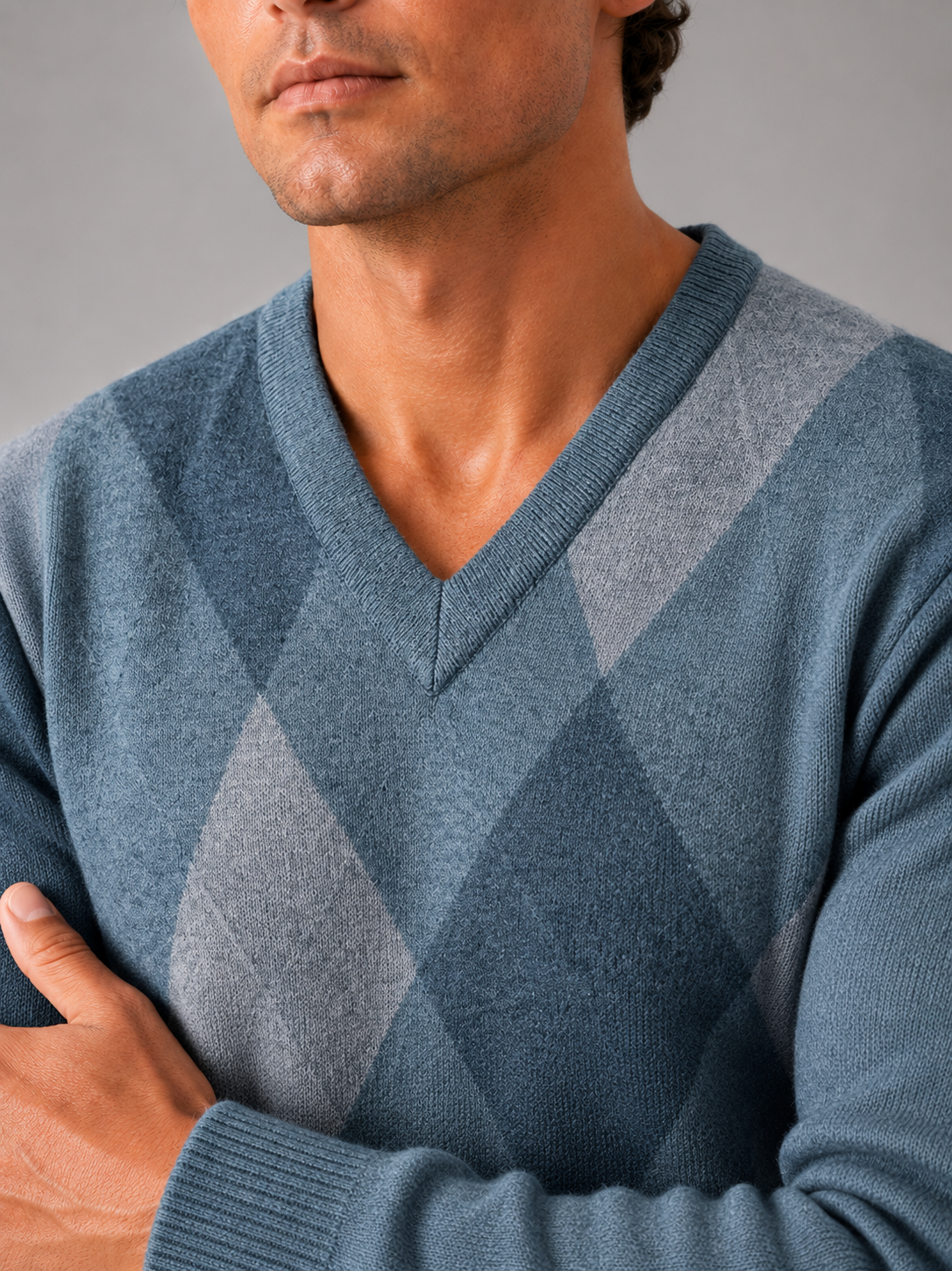 Close up of blue plaid knit sweater showing soft textured fabric and refined v neck detail
