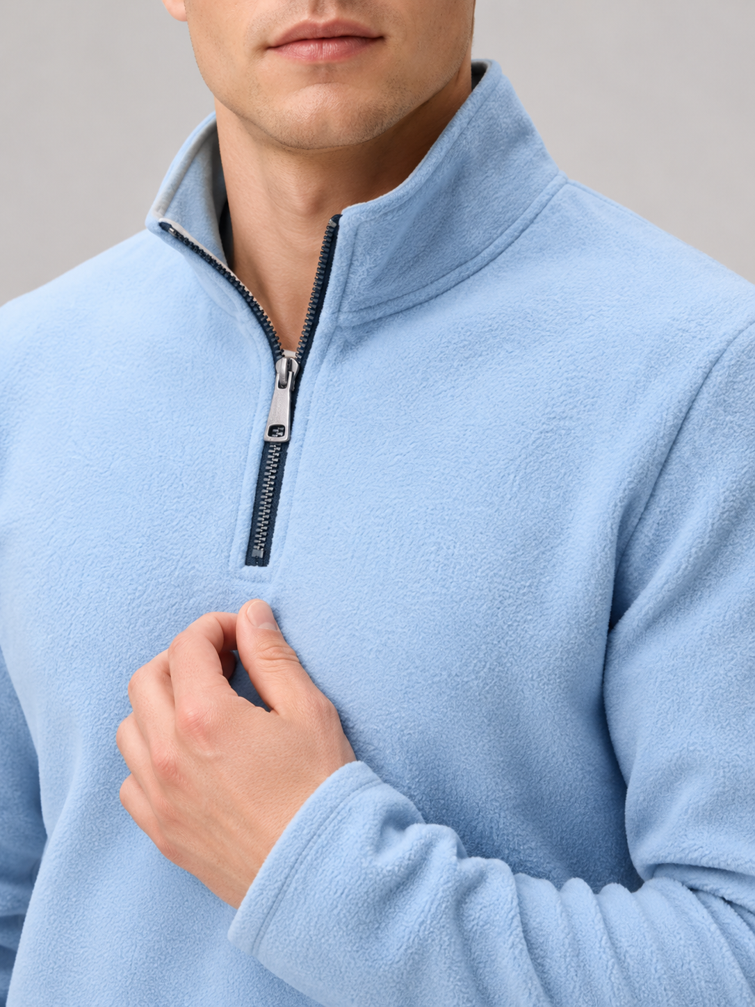 Close up of blue fleece pullover showing soft thermal fabric and quarter zip mock neck detail