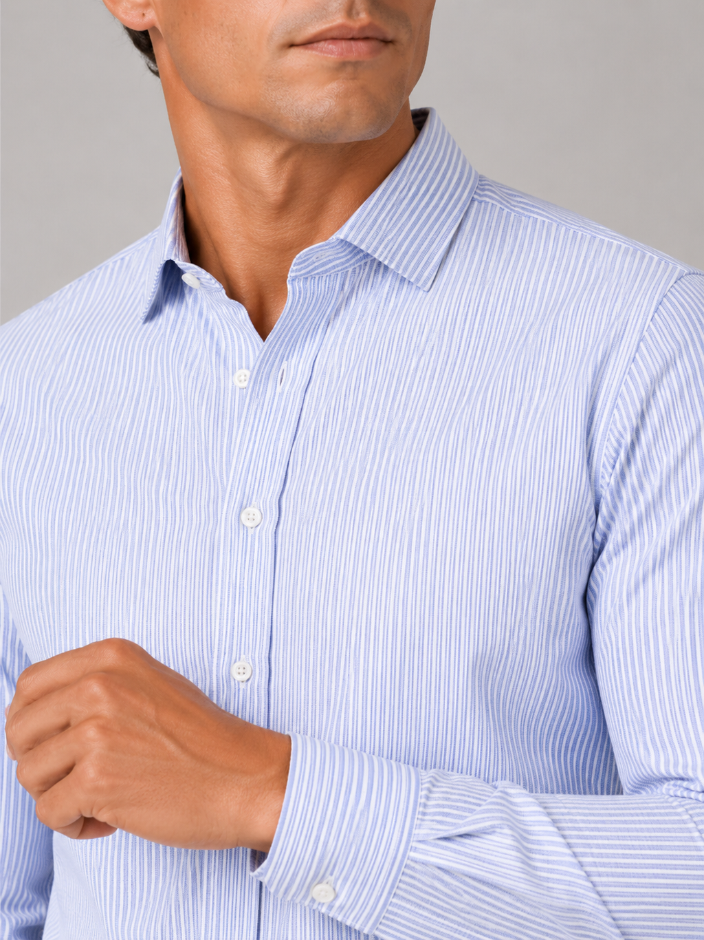 Close up of blue striped oxford shirt showing soft cotton fabric and refined button up detail