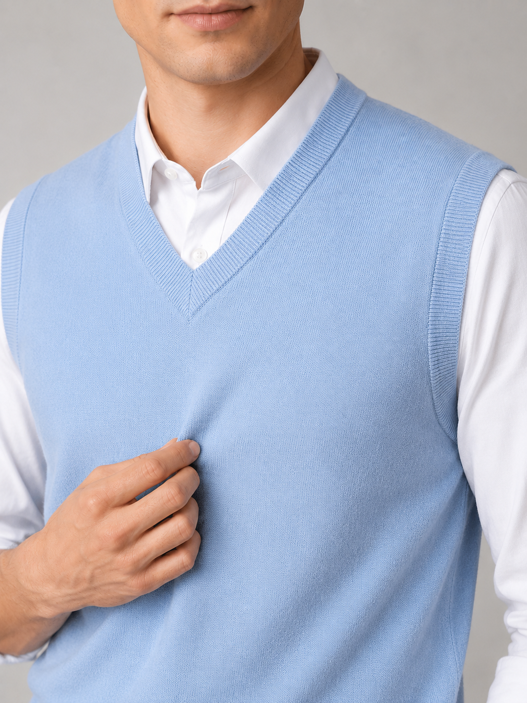 Close up of blue sweater vest showing soft knit texture and classic v neck detail