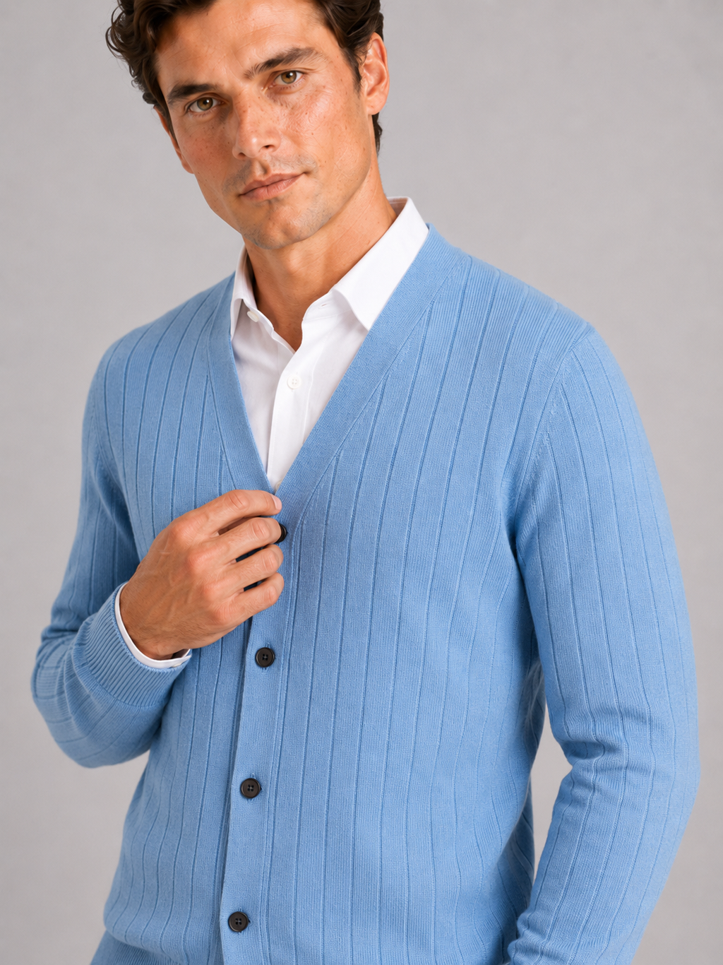 Close up of blue knit cardigan showing soft lightweight texture and refined button front detail