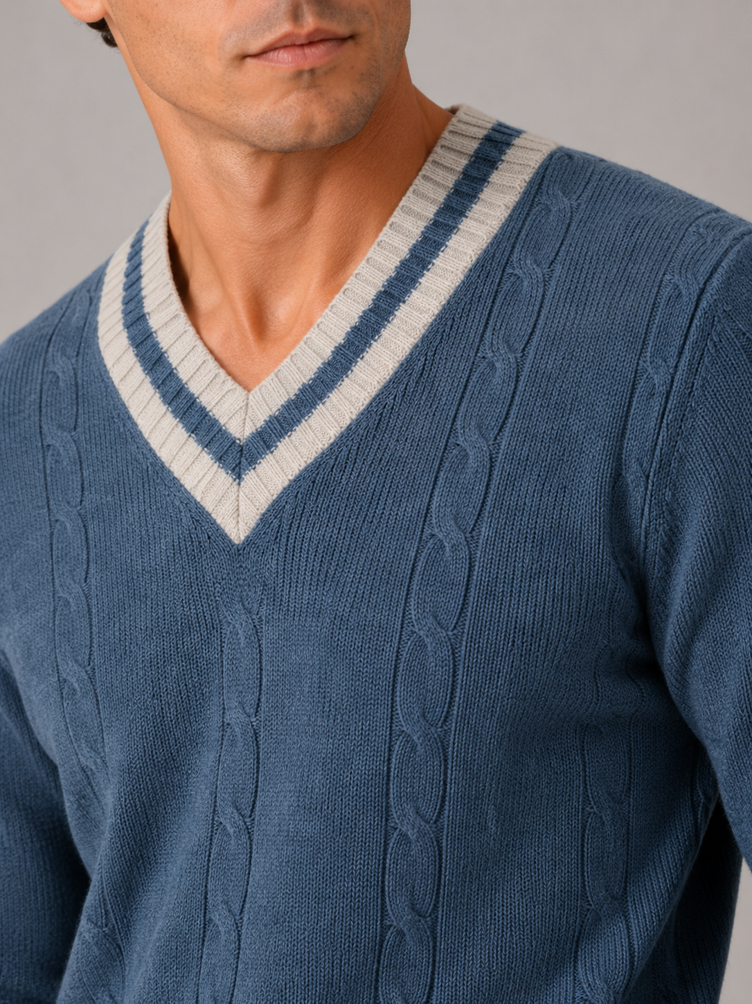 Close up of blue knit sweater showing soft warm fabric and refined v neck detail