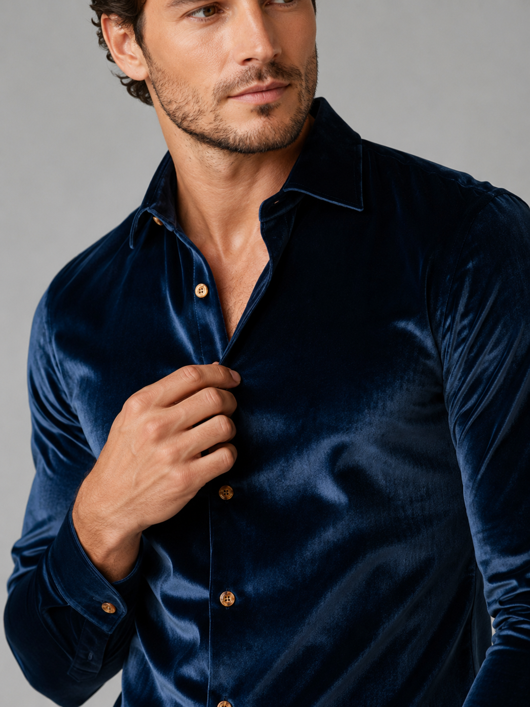 Close up of blue velvet shirt showing soft lustrous texture, lapel collar, and button front detail