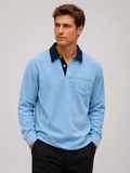 Front view of a man wearing a blue corduroy long sleeve polo shirt with a contrast turn-down collar and relaxed fit