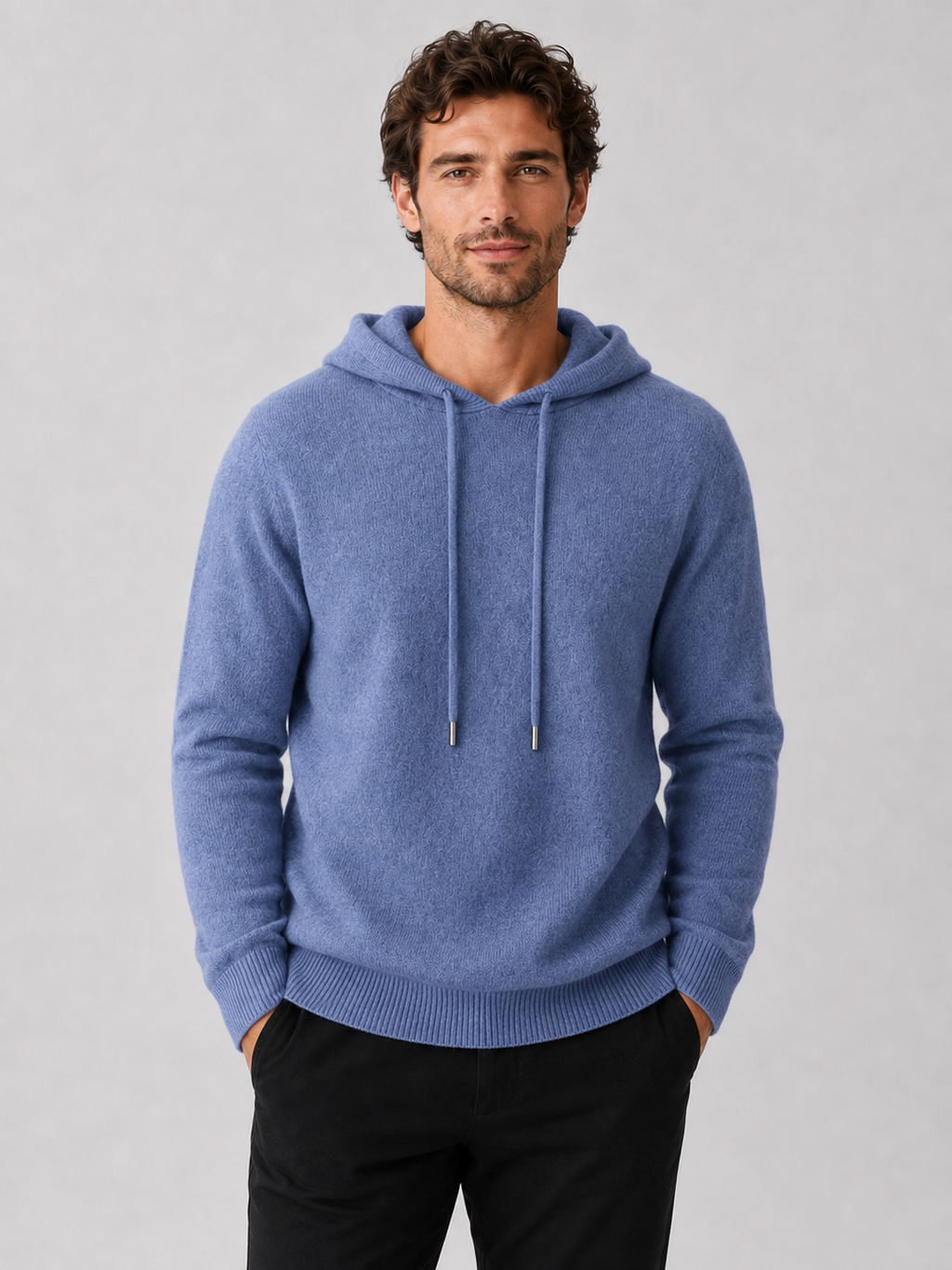 Front view of a man wearing a blue wool hoodie sweater with a soft knit design, attached hood, and long sleeves