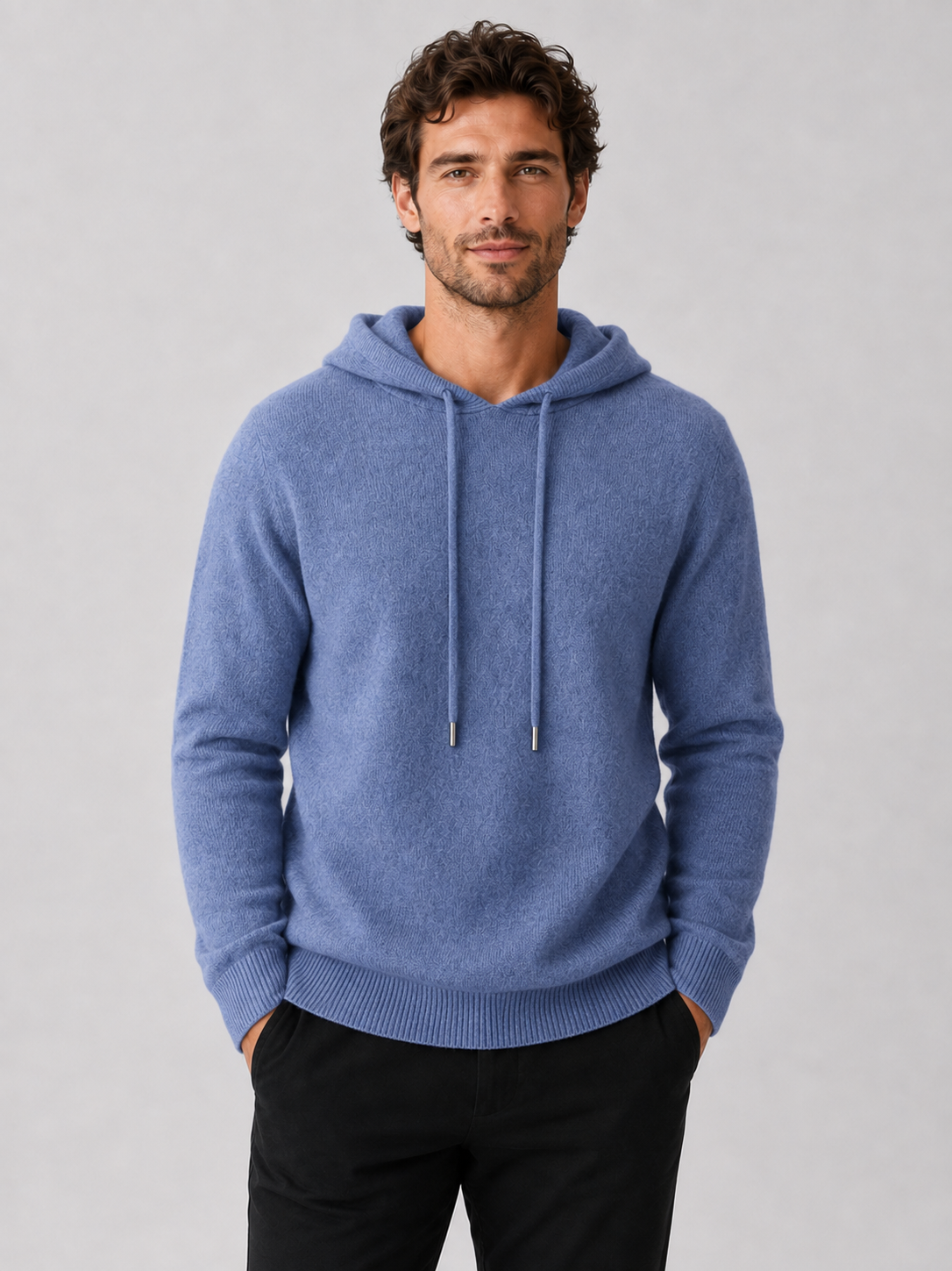 Front view of a man wearing a blue wool hoodie sweater with a soft knit design, attached hood, and long sleeves