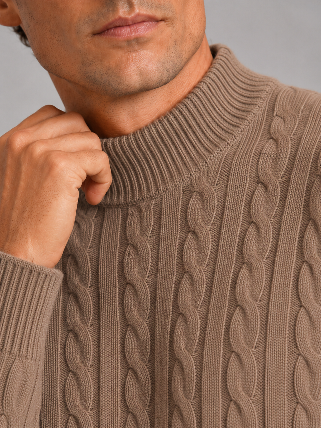 Close up of brown wool cable knit sweater showing soft texture and mock neck detail