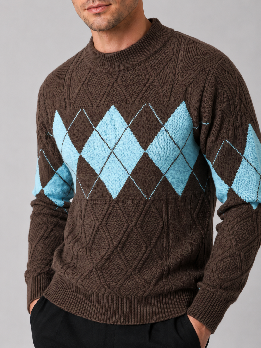 Close-up of a brown argyle cable knit sweater showing the cable knit texture, argyle pattern, patchwork details, mock neck, ribbed cuffs, and hem